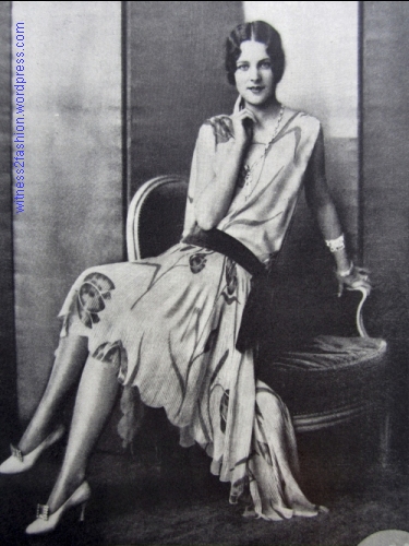 Hattie Carnegie dress with large-scale print and scalloped hem, much longer in back than in front. Delineator, July 1928.